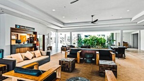 En rummelig lobby med en receptionsdisk, komfortable siddepladser og store vinduer, der lukker naturligt lys ind.