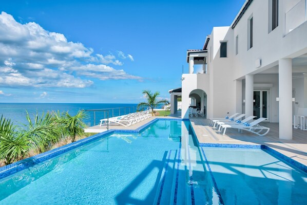 Alberca al aire libre y camastros 