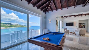 A pool table with a clear view of the ocean and a balcony with white furniture. - Villa Amalia (Philipsburg)