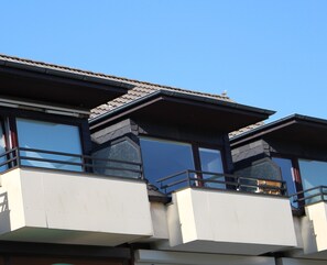 A building with multiple balconies, large windows, and a tiled roof. - Büsum-Perle: Your domicile in the heart of Büsum (Büsum)