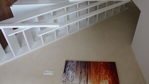 A staircase with white railings and a wall-mounted light switch.