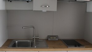 A modern kitchen with a stainless steel sink, a microwave, and a built-in oven.