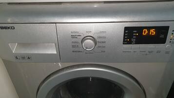 A front view of a BEKO washing machine with a digital display, control panel, and a transparent door.