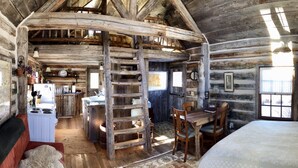 A rustic cabin interior with a kitchen, dining area, and a cozy sleeping area. - Cozy, Rustic Cabins near Chico Hot Springs & only 35 mins to YELLOWSTONE PARK!! (Pray)