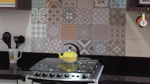 Une cuisine équipée d’une cuisinière à gaz, d’un four et d’un mur orné de différents types de carreaux décoratifs.