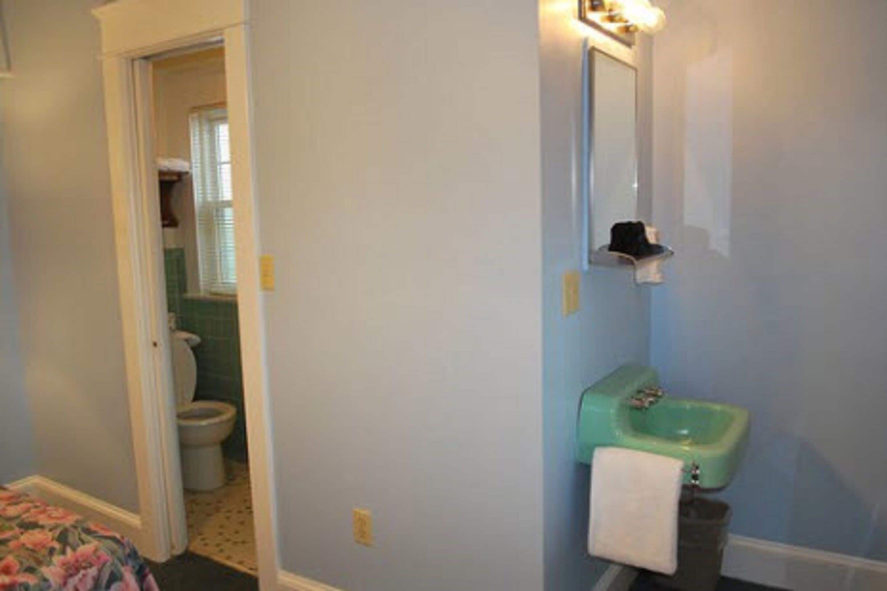 Et badeværelse med toilet, håndvask og spejl.