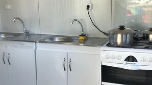 A kitchen with two sinks, a stove, and cabinets. - Bodrum Masali Camping - Hostel (Bodrum)