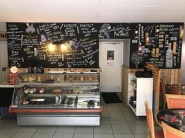 A café with a chalkboard menu listing items like 'Burger du Berger' and 'Entrecote'.