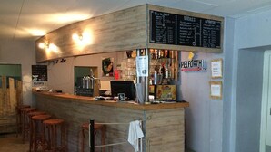 Een bar met krukken, een toonbank en een menubord.