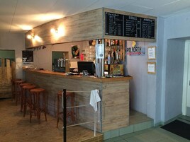 A bar area with stools, a counter, and a menu board.