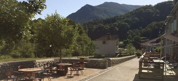 A restaurant with outdoor seating overlooking a mountain.