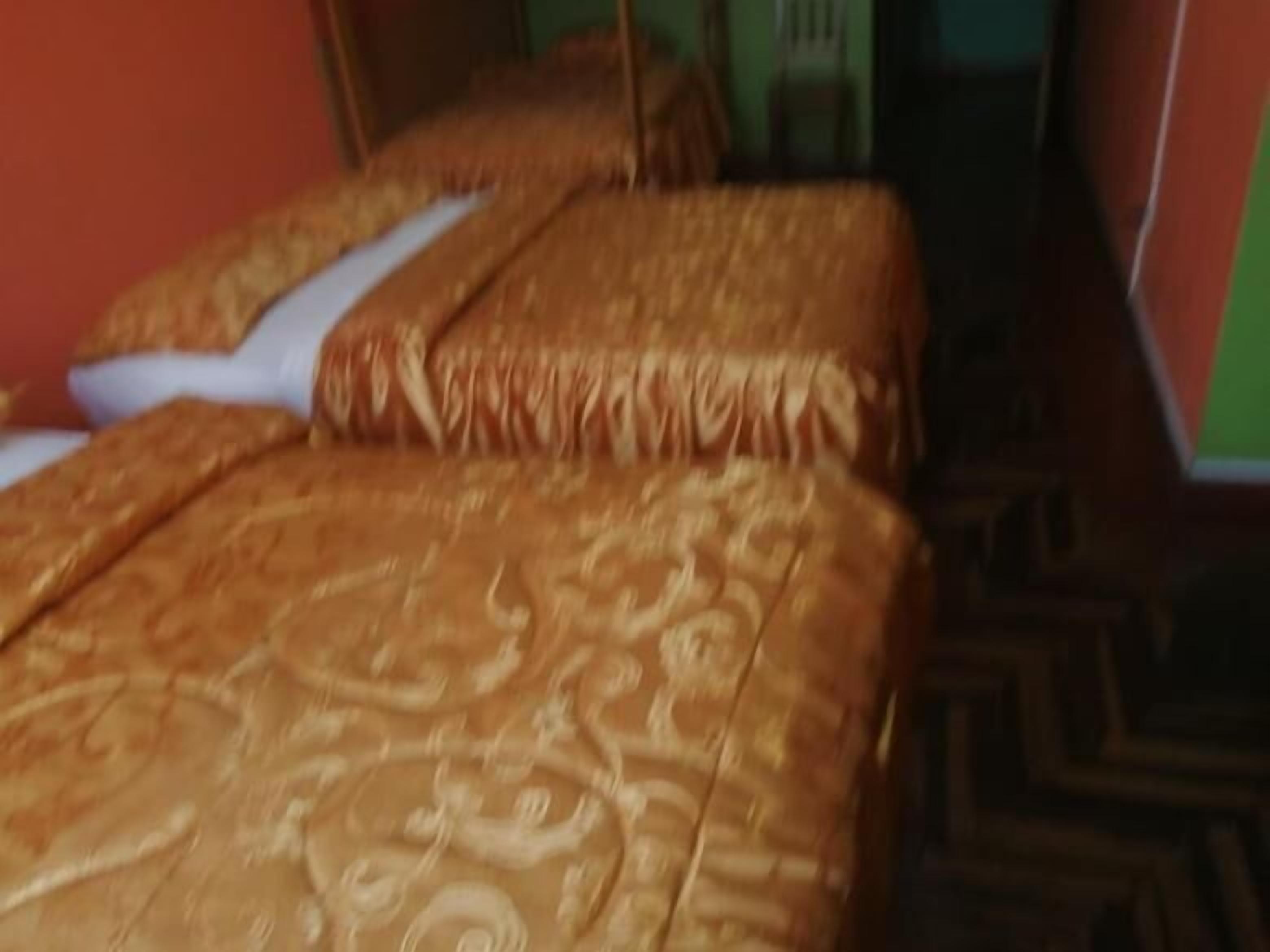 A bed with a patterned bedspread and pillows.