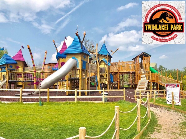 Un terrain de jeux doté de nombreuses installations, notamment des toboggans et des structures d’escalade, le tout délimité par une clôture.