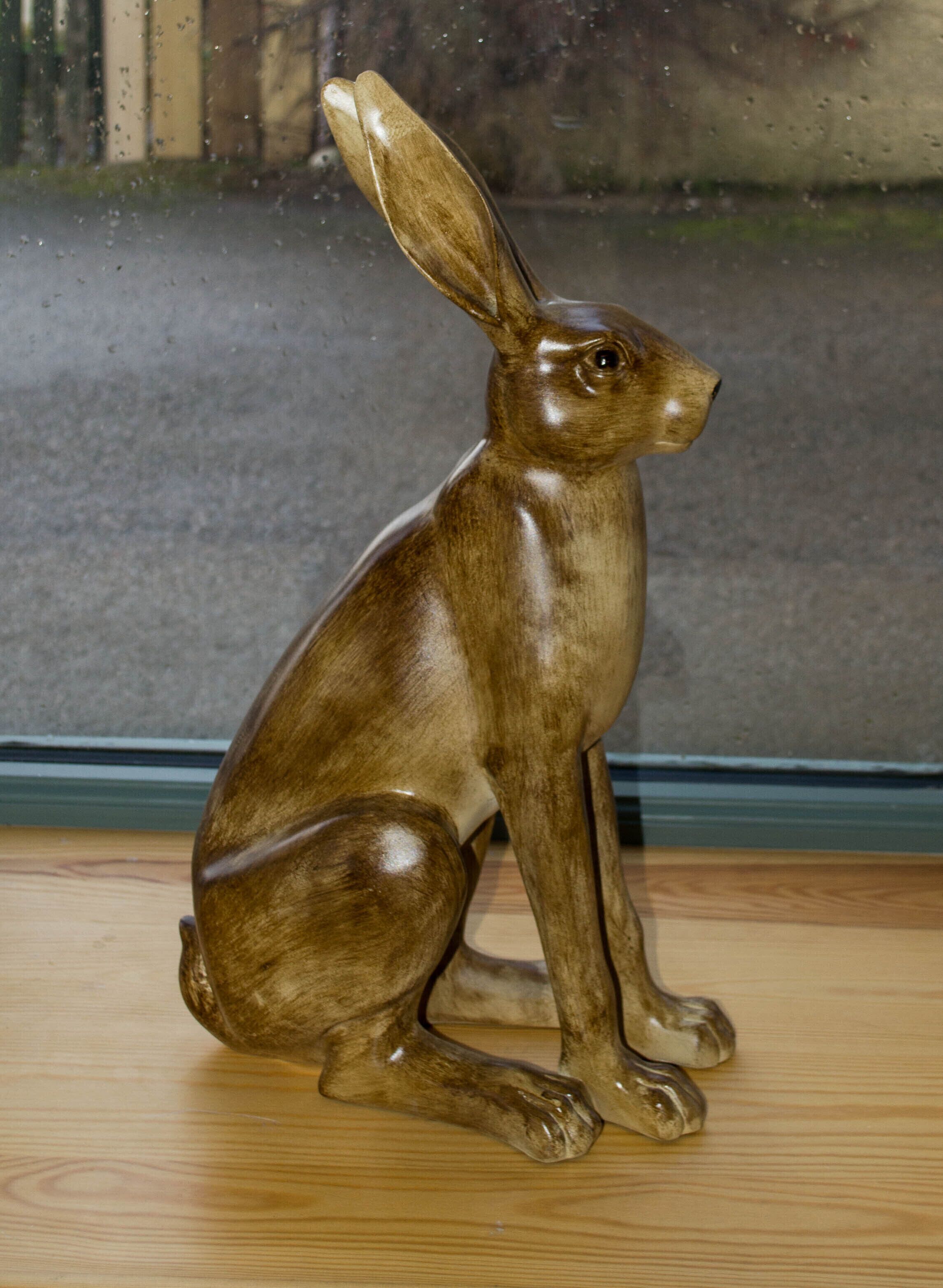 Una figurita de conejo de madera sobre una superficie de madera.