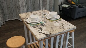 A small kitchen area with a marble countertop, two white bowls, a glass, and a wooden stool. - WanderLost WanderLoft - Ideal for ATU grad student, visiting faculty, ANO outage (Dover)