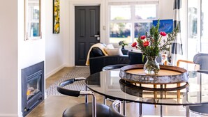 Un salon moderne avec une table basse en verre, une cheminée et un canapé.