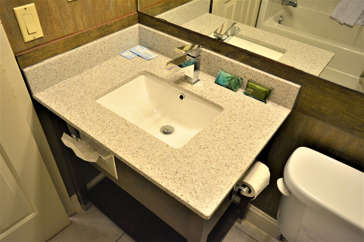 A bathroom with a sink, mirror, and toilet.
