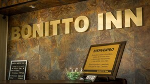 A reception desk with a 'BONITTO INN' sign, a welcome sign, and a price list for hotel rooms. - BONITTO INN® Tampico Altamira (Altamira)