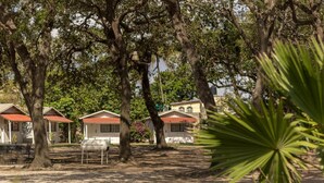A row of cabins with red roofs, surrounded by trees and a dirt ground. - BONITTO INN® Tampico Altamira (Altamira)