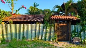 Una casa de fusta rústica amb teulada de rajola, una porta de fusta i una petita construcció de fusta amb la inscripció "merai".