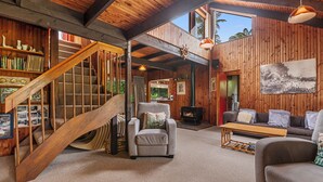 Un interior de madera con una escalera, una chimenea y un sofá.