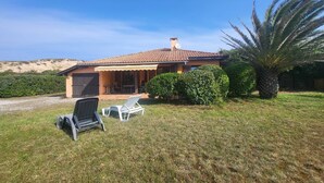 A house with a tiled roof, a covered patio, and two lounge chairs. - The "Maison des Moineaux" between lake and ocean for 6 persons (Soorts-Hossegor)