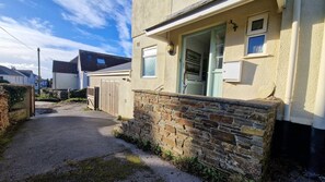 A residential property with a stone wall, a wooden gate, and a clear sky. - 2 Steepfield, spacious apartment, Bantham S. Devon (Bantham)