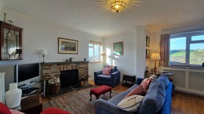 A living room with a fireplace, a television, and a sofa.