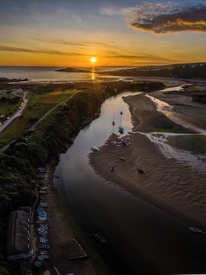 Ein Fluss mit Booten, eine Straße und ein Sonnenuntergang.