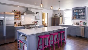 Una cocina moderna con una isla grande, electrodomésticos de acero inoxidable y un ambiente luminoso y espacioso.