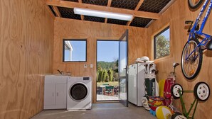 A compact room with a washing machine, a compact fridge, and a bicycle.