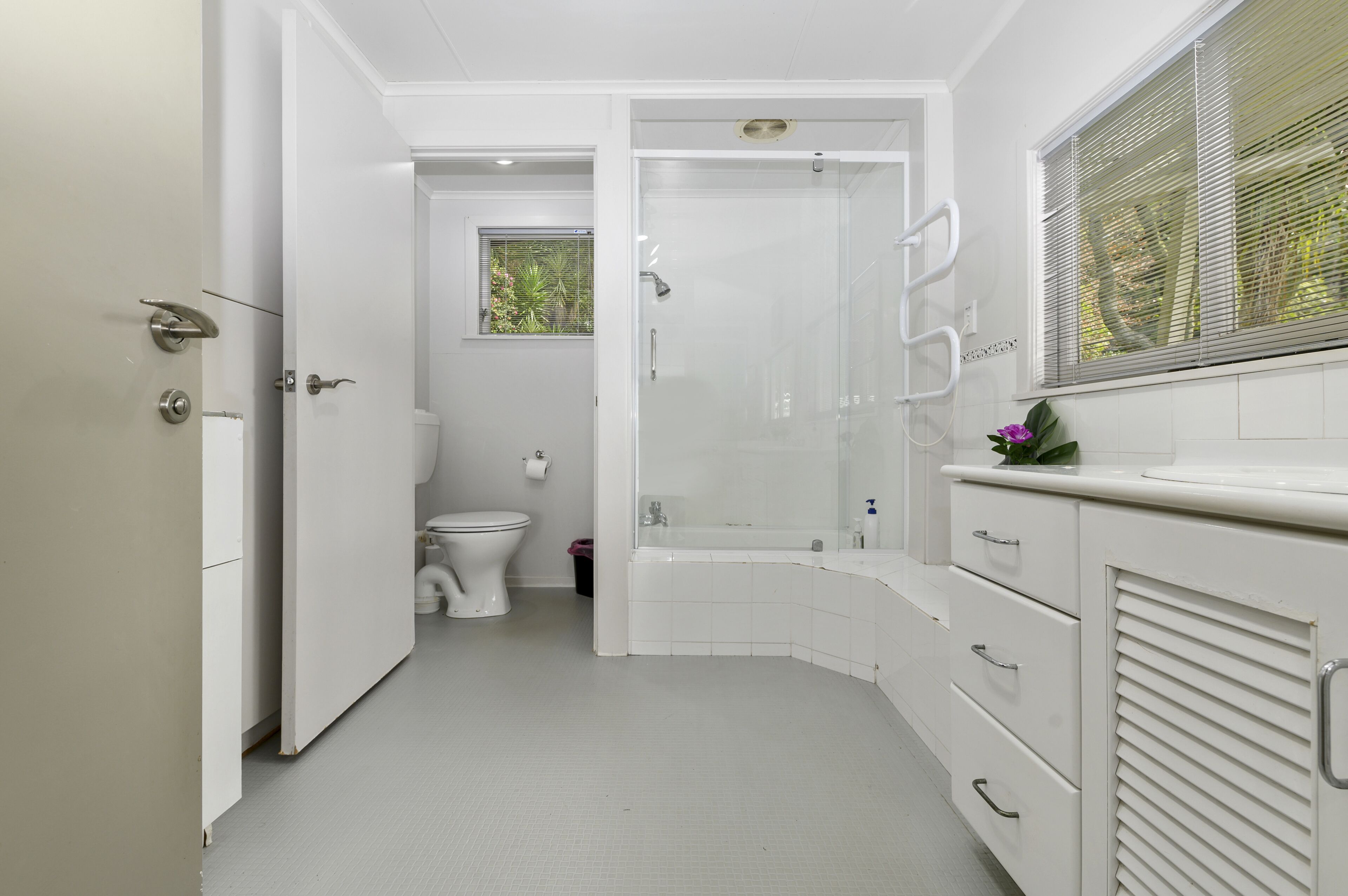 A modern bathroom with a shower, toilet, and sink.