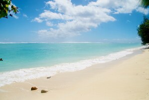 A beach with clear turquoise water, white sand, and a few rocks. - Teiao Beachfront Aroa Beach (Arorangi)
