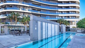 Un hôtel moderne doté d’une piscine, d’un espace extérieur aménagé et d’un bâtiment à plusieurs étages avec des balcons.
