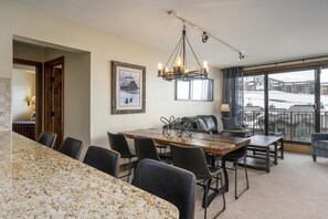 Enjoy a spacious room with a dining table, sofa, and armchairs, plus a large window with a scenic view.