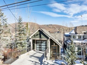A residential building with a garage, a front porch, and a snow-covered landscape. - Abode at Powder Watch, private hot tub, heart of Park City, near ski lift (Park City)
