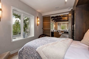 Un dormitorio con una cama grande, una ventana, un escritorio y un armario.