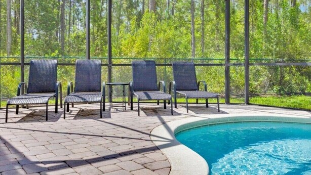 An outdoor pool area with four lounge chairs and a pool. - More 4 your Money w/ Private South Facing Pool (Kissimmee)