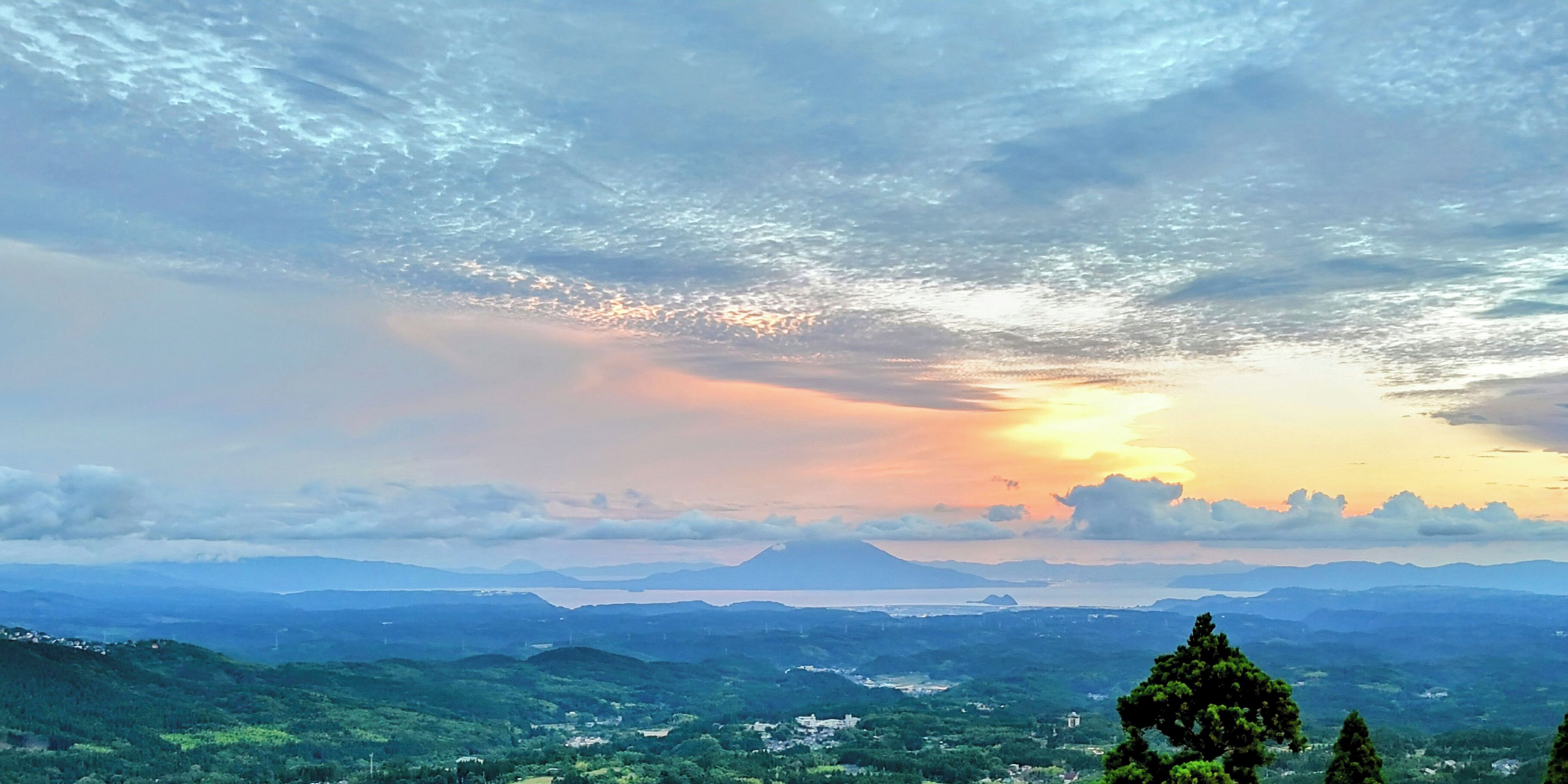 Vista panorámica de un paisaje montañoso con un atardecer.