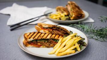 Un plato con un sándwich a la plancha y papas fritas.