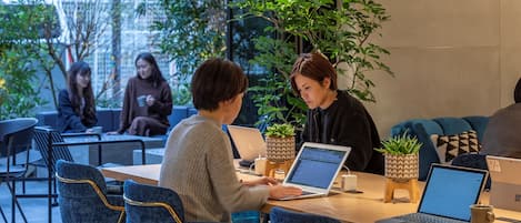 Ein moderner Innenraum mit einem langen Tisch, mehreren Stühlen und zwei Laptops.