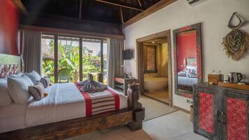 A bedroom with a large bed, a wooden headboard, a TV, a mirror, and a view of the outdoors.