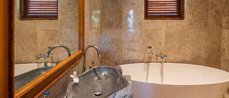 A bathroom with two sinks, a large bathtub, and a mirror.