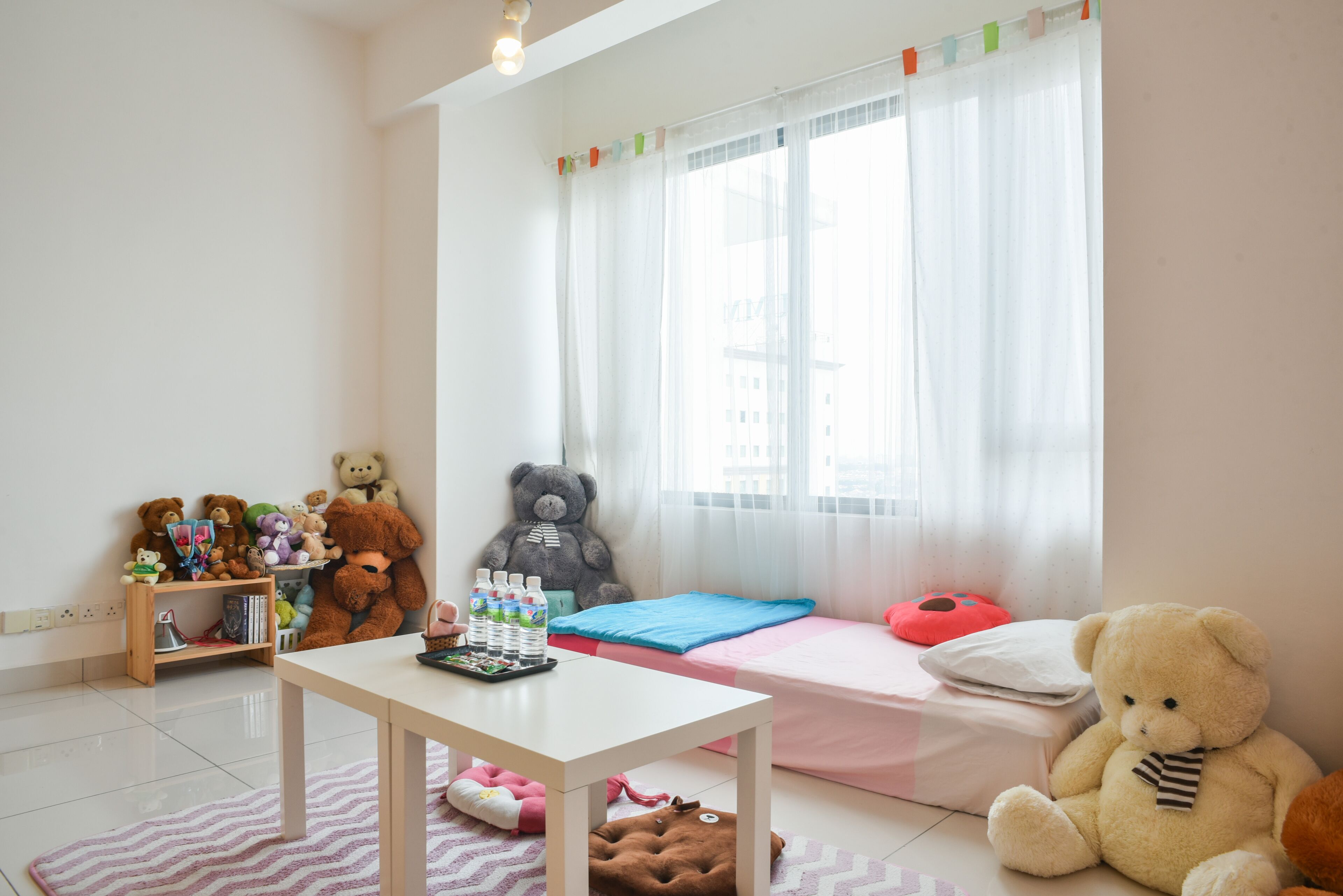 Un dormitorio infantil con una cama, un escritorio y una ventana con cortinas.