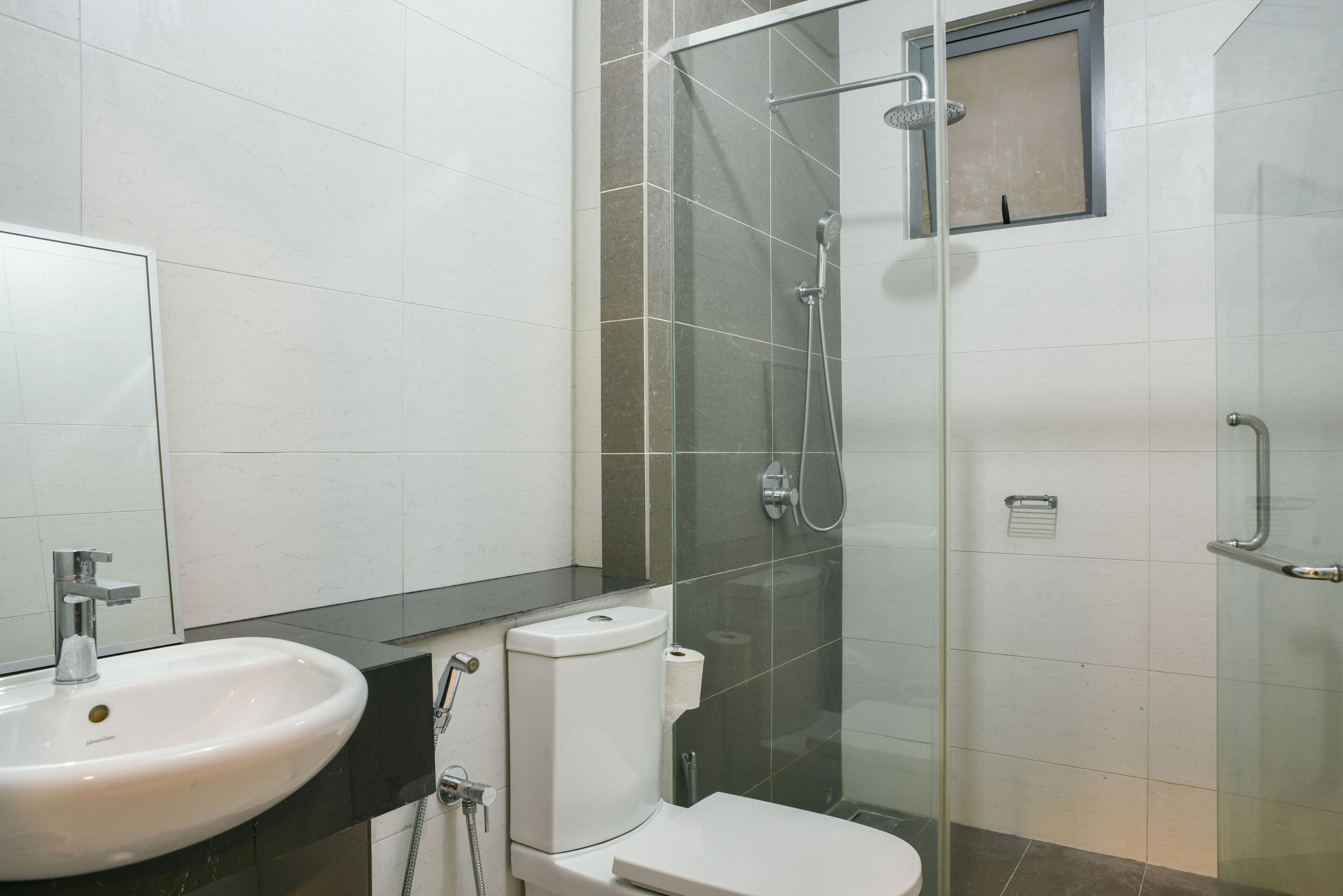 A bathroom with a white sink, a toilet, and a glass-enclosed shower area.