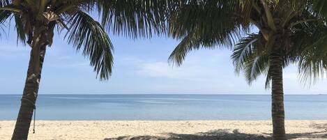 Rannalla, aurinkotuoleja, rantapyyhkeitä