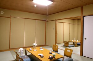 A traditional Japanese-style room with tatami flooring, a low wooden table set for tea, and sliding doors. - Hotel Ryuo (Yamanouchi)