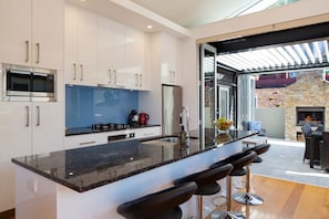 Enjoy meals in the kitchen with a large island and dining area, then step outside to a patio with a fireplace.