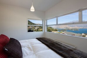 Enjoy breathtaking views of the surrounding mountains and water from this serene bedroom.