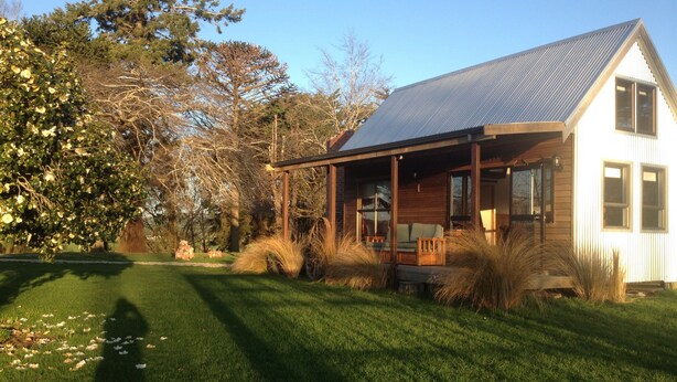 A house with a covered porch, a lawn, and trees.